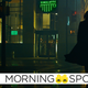 A coated figure cloaked in shadow walks towards the neon signs of a Simulatte coffee shop in a scene from The Matrix: Resurrections